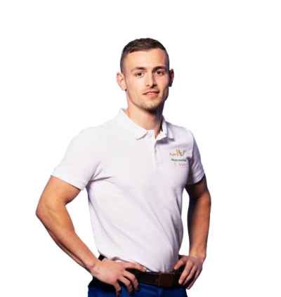 Auszubildender Erwin wird Elektroniker für Energie-und Gebaeudetechnik, hat Hände in den Hueften und laechelt, traegt Schutzkleidung, weißes T-Shirt, dunkelblaue Hose
